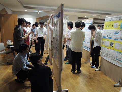 学生がポスター発表用簡易パネルを見ています。